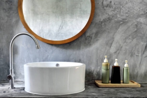 Vasque de salle de bain avec miroir en bois au dessus et pots à savon à côté
